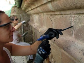 Patrícia Amat i Judit Birosta, treballant a la façana de Sant Mateu del monestir de Sant Joan de les Abadessses ACN