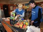 Alguns voluntaris en un supermercat de Llagostera, adherit a la campanya de recollida d'aliments. JOAN SABATER