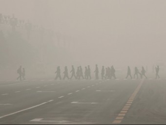 Diverses persones travessen un pas de vianants a la plaça Tiananmen, aquest dilluns a Pequin REUTERS