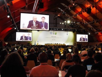 Els delegats assistents al COP21, segueixen la compareixença de Laurent Fabius, aquest dimecres a Le Bourget, als afores de París EFE