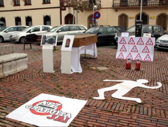 Pancarta reivindicativa, un taüt i una silueta a terra, davant la delegació de Tarragona de Foment ACN
