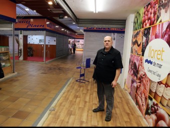 El president de l'Associació de Concessionaris de mercat municipal de Lloret, Julián García, en una parada que es fa servir d'exposició.  Manel Lladó