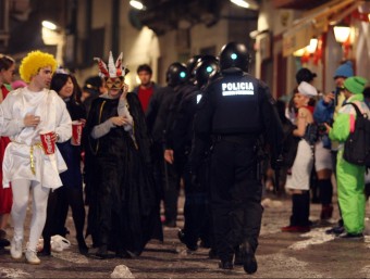 Agents antidisturbis dels Mossos creuant entremig de persones disfressades en una edició del Carnaval de Sitges O.DURAN