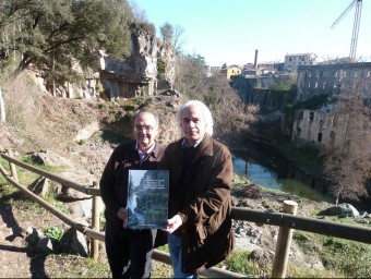 Josep Oliveras i Manel Soler, amb el llibre que han redactat, fotografiats a la cinglera del Molí Fondo. J.C