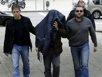 Joaquín Benítez , tapat amb la jaqueta i acompanyat de tres mossos, ahir al jutjat EFE