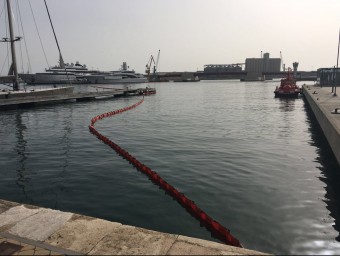 Barrera de contenció que es va col·locar al moll de Costa per protegir la zona del port que estava neta EL PUNT AVUI