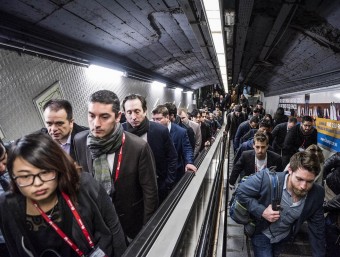 Ciutadans ahir al metro de Barcelona alguns amb la credencial del congrés de mòbils penjda del coll, sortint d'una andana JOSEP LOSADA