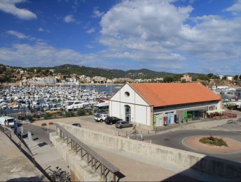 El Tinglado del port de Sant Feliu, en primer terme, seu de l'Estació Nàutica guixolenca E.A
