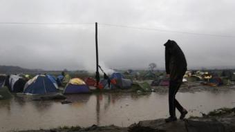 Un refugiat camina per un campament de refugiats inundat per les pluges, al costat de la frontera entre Grècia i Macedònia EFE