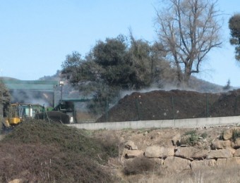 Una màquina treballant a la planta de compostatge Fumanya, amb matèria que fumeja ANNA AGUILAR