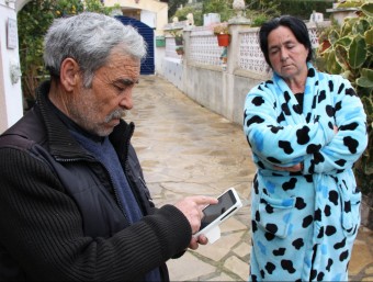 Juan María Gallegoi Inés de Ávila, pares del noi mort a Cunit, mostren als periodistes imatges de la detenció al mòbil. ACN
