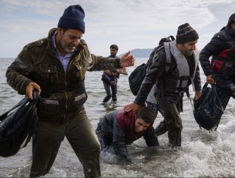 Un grup de refugiats desembarcant d'una llanxa a la costa de l'illa de Lesbos (Grècia), ahir EP