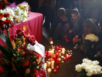 Diverses persones encenen espelmes en memòria de les víctimes de l'accident d'autocar, ahir a l'edifici històric de la UB REUTERS