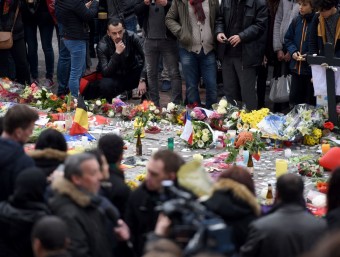 Un home observa les flors i els missatges que la gent ha deixat en homenatge a les víctimes, en una plaça de Brussel·les. AFP