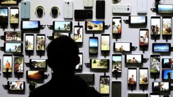 Un visitant d'una fira tecnològica mira tota la gamma de dispositius d'una coneguda marca justin sullivan / AFP