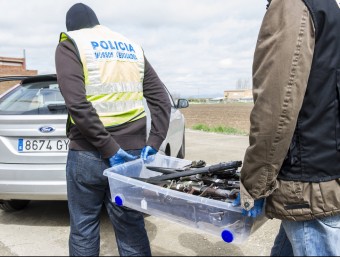 Agents dels Mossos i la Guàrdia Civil s'enduen una capsa plena d'armes blanques, aquest dimecres a El Poal EFE