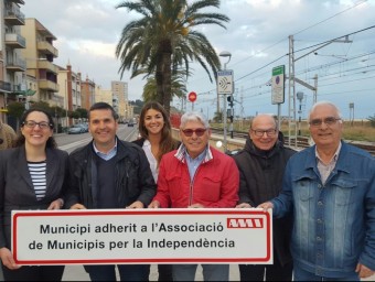 Militants de totes dues formacions amb Francesc Garcia (CiU) i Jordi Abad (MES) al centre de la imatge amb un dels cartells d'adhesió a l'AMI que han comprat per Montgat. F.G