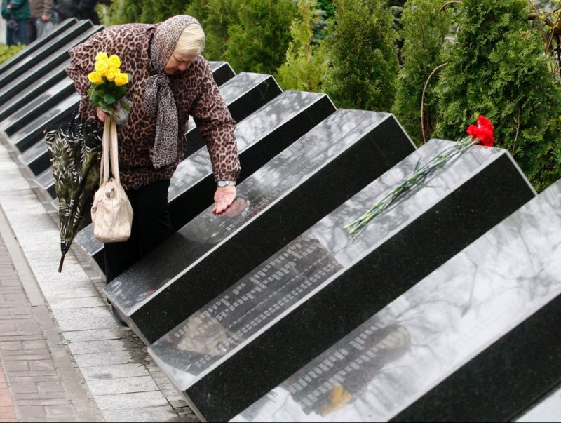 Una dona resa en un memorial de les víctimes de Txernòbil.  AFP