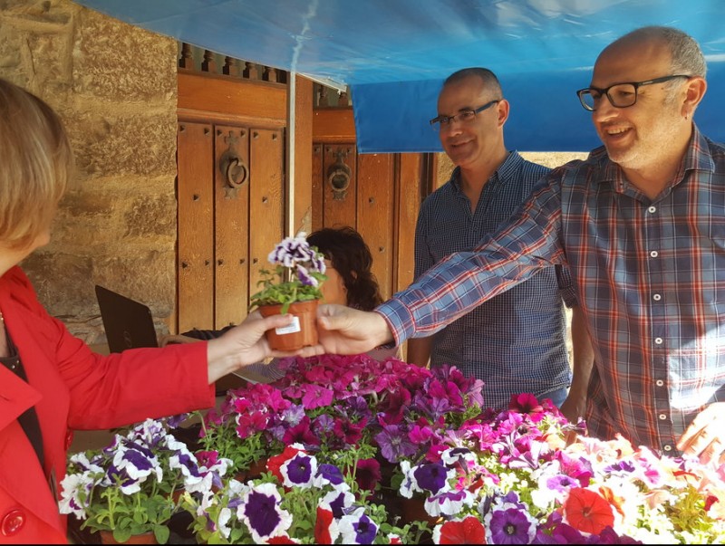 El regidor Josep Illa i l'alcalde Xavier Codina repartint flors entre els veïns de Santpedor AJS