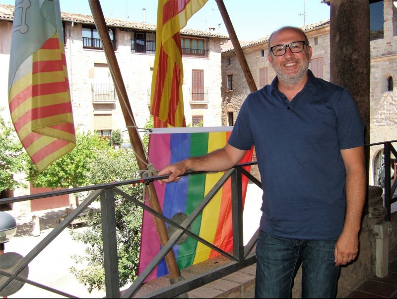 Codina, fotografiat al balcó de l'Ajuntament el 28 de juny; amb la bandera de l'arc iris al fons C.O