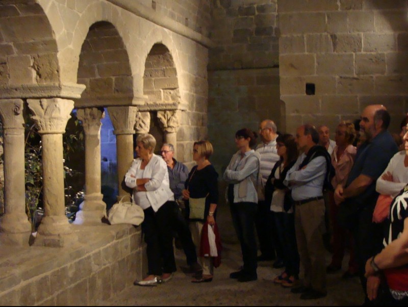 El primer grup de visitants en realitzar la visita 'Ramon Casas i la mirada de Júlia', atents a una projecció audiovisual al claustre del monestir N.B