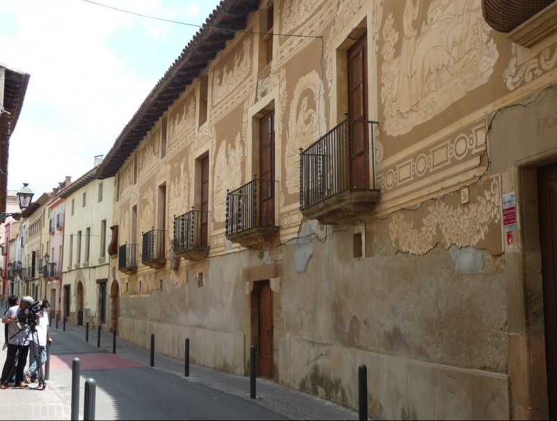 L'edifici destaca pe la seva impressionant i allargada façana plena amb els esgrafiats de Ferdinandus Serra. AJUNTAMENT DE PIERA