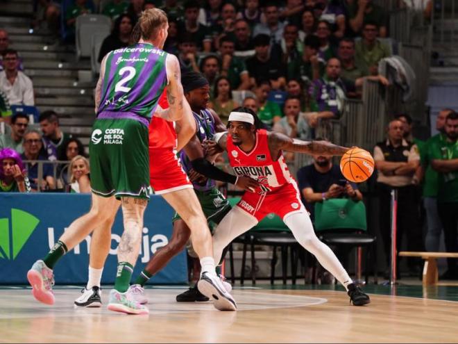 Ike Iroegbu, amb la pilota a les mans, defensat per Kendrick Perry